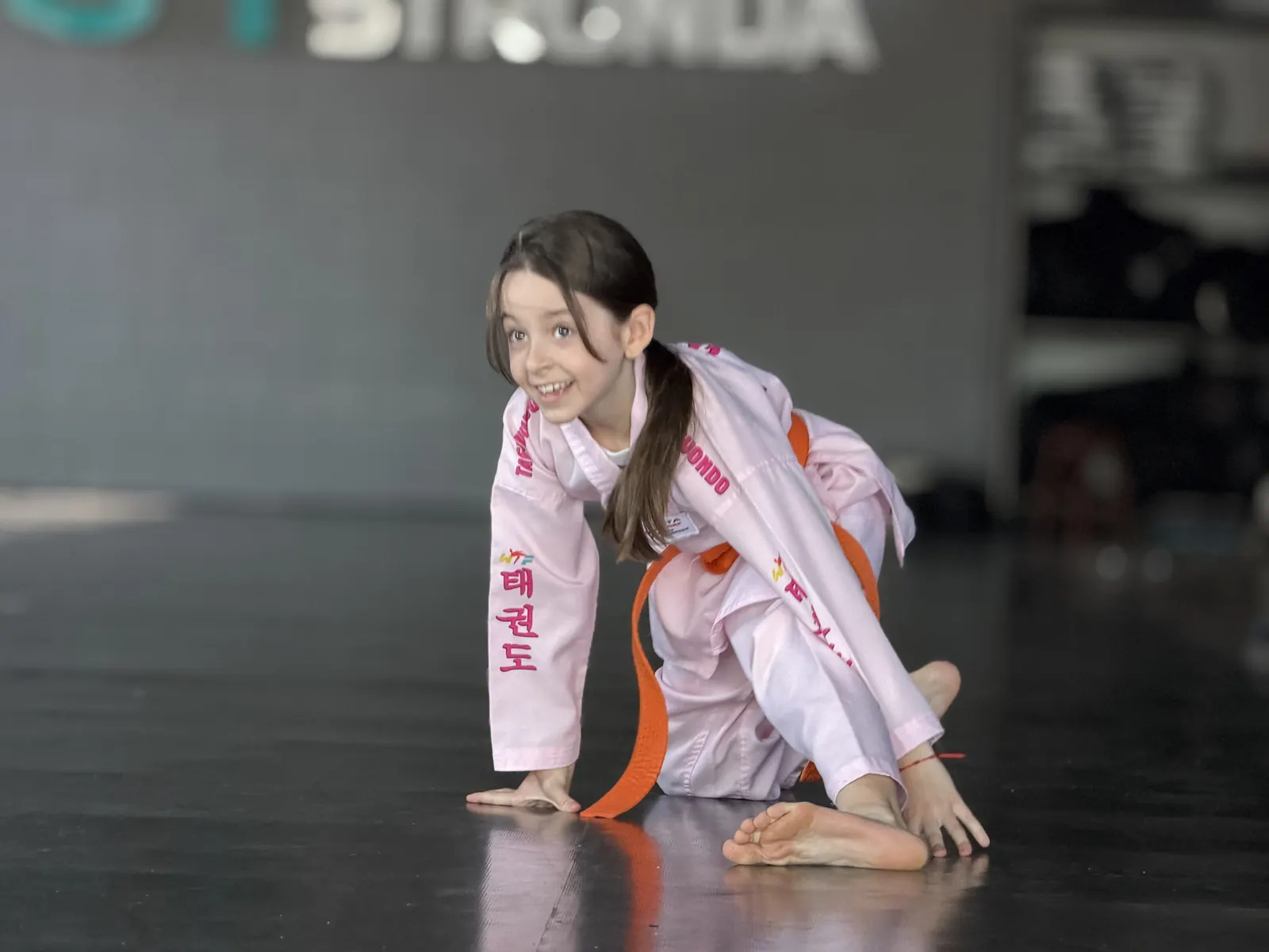 Professor ensinando uma aluna no Taekwondo do CT Stronda